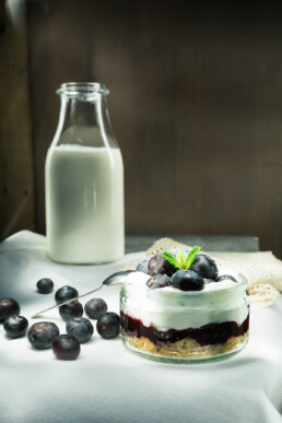 Food photo of blueberry cheesecake and bottle of milk in the background