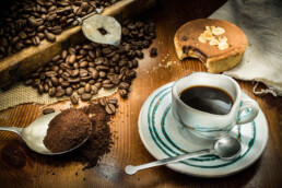 Food photography, foodie photo of table with coffee and cake with ground coffee in the foreground